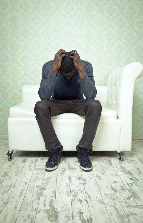 Grieving man with his hands on his head.